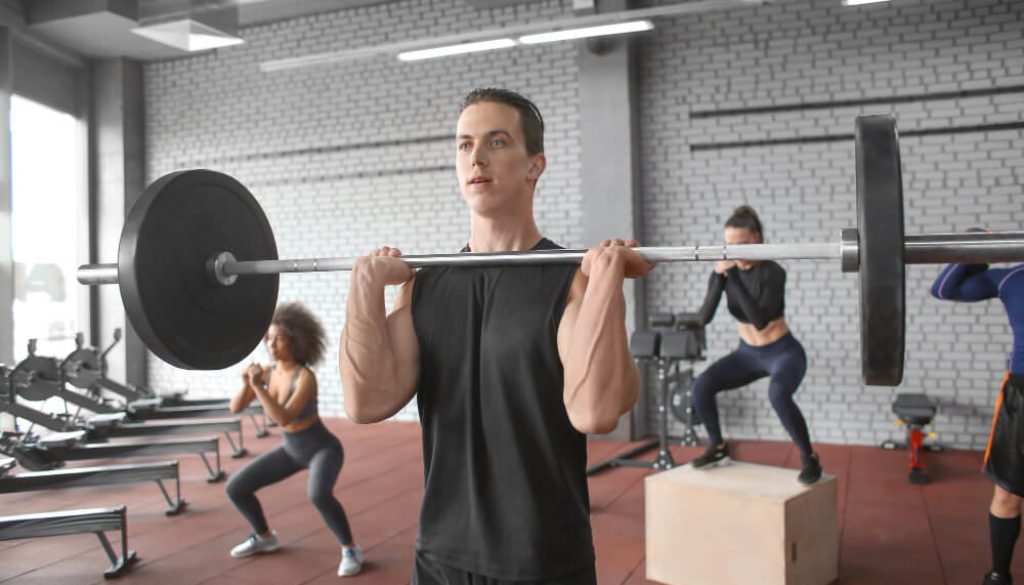 cross training-man-training-with-barbell-modern-gym