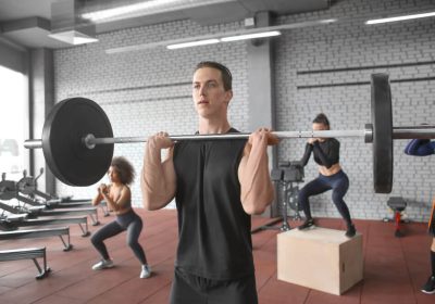 cross training-man-training-with-barbell-modern-gym